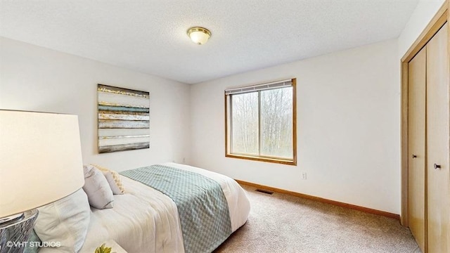bedroom featuring baseboards, carpet, a closet, and visible vents