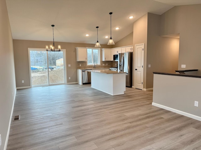 kitchen with visible vents, white cabinetry, a chandelier, appliances with stainless steel finishes, and vaulted ceiling