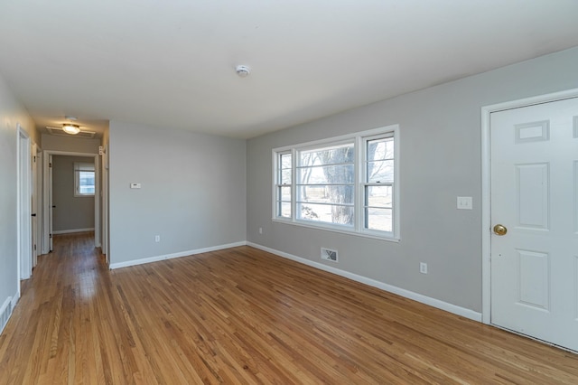 unfurnished living room with baseboards, light wood-type flooring, and healthy amount of natural light