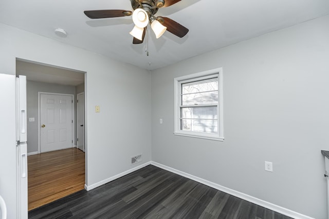 spare room featuring dark wood-style flooring, baseboards, and ceiling fan