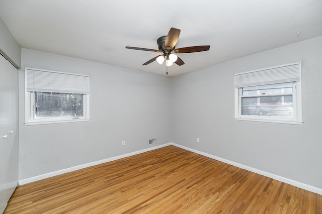 spare room with healthy amount of natural light, light wood-style flooring, and baseboards