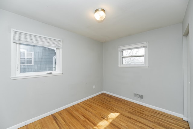 empty room featuring baseboards and light wood-type flooring