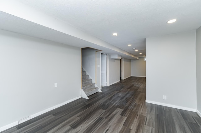 finished basement featuring dark wood finished floors, baseboards, recessed lighting, and stairs