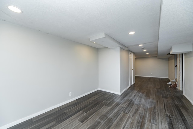 finished below grade area with dark wood-type flooring, baseboards, and recessed lighting