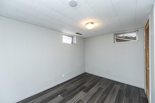 basement featuring dark wood-style flooring and baseboards