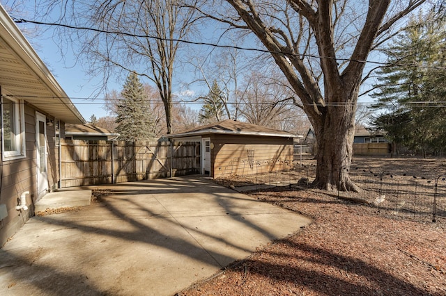 view of yard with fence, a patio area, and an outbuilding
