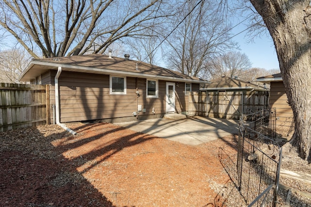 back of property with fence and a patio
