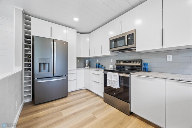 221 26th Ave N, Fargo, ND 58102 - kitchen with stainless steel appliances, light wood-type flooring, white cabinets, light stone counters, and recessed lighting