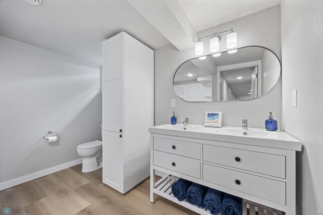 221 26th Ave N, Fargo, ND 58102 - bathroom with wood finished floors, toilet, double vanity, and baseboards