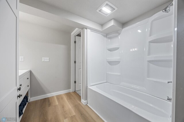 221 26th Ave N, Fargo, ND 58102 - full bath featuring wood finished floors, bathing tub / shower combination, vanity, and baseboards