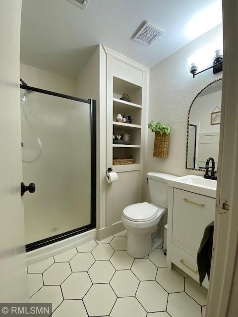 bathroom with visible vents, a stall shower, toilet, and vanity