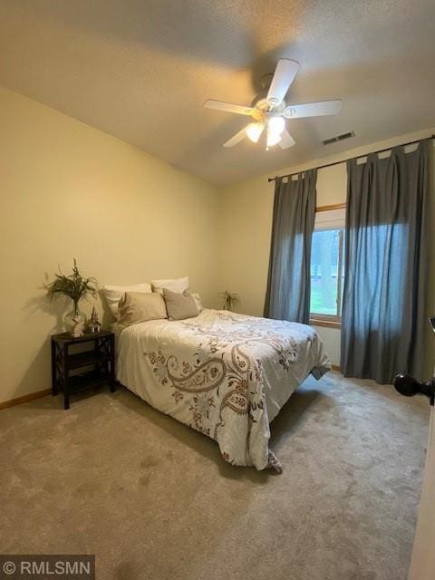carpeted bedroom with baseboards, a ceiling fan, and visible vents