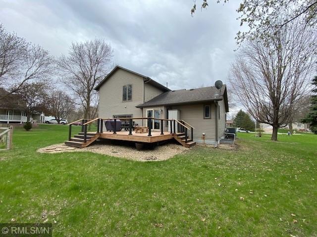 rear view of house with a wooden deck and a yard