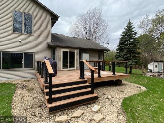 back of house featuring a lawn and a wooden deck