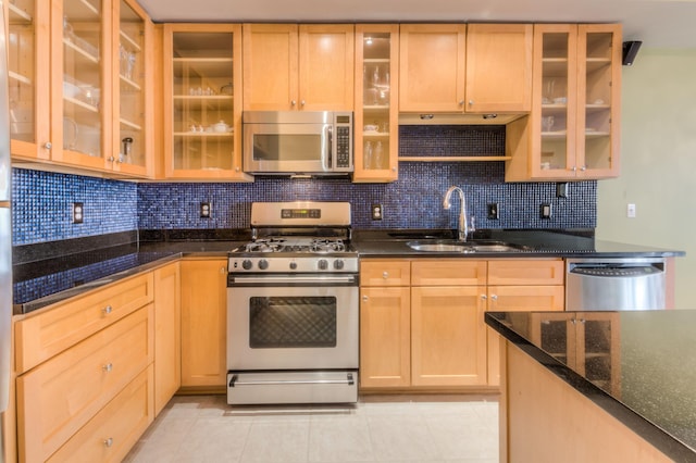 kitchen featuring a sink, glass insert cabinets, backsplash, and stainless steel appliances