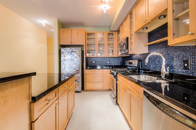 kitchen with light brown cabinetry, stainless steel appliances, decorative backsplash, and a sink