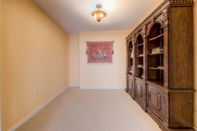 interior space with baseboards and light carpet