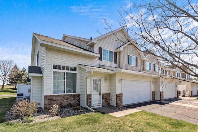 view of front of home featuring brick siding, asphalt driveway, and an attached garage