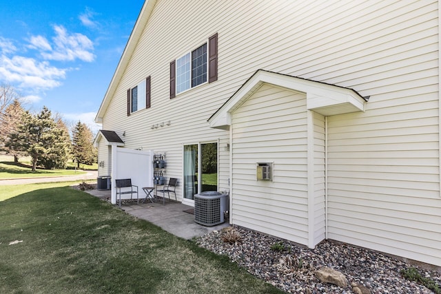 back of house with central AC unit, a patio, and a lawn