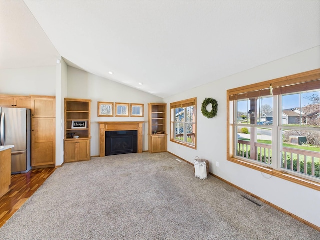 2200 Orchid Dr NE, Sauk Rapids, MN 56379 - unfurnished living room featuring a fireplace, carpet floors, visible vents, baseboards, and vaulted ceiling
