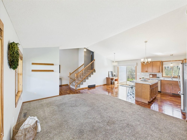 2200 Orchid Dr NE, Sauk Rapids, MN 56379 - kitchen with a center island, dark carpet, light countertops, appliances with stainless steel finishes, and vaulted ceiling
