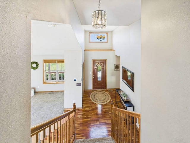 2200 Orchid Dr NE, Sauk Rapids, MN 56379 - foyer featuring wood finished floors, high vaulted ceiling, baseboards, a textured wall, and a notable chandelier