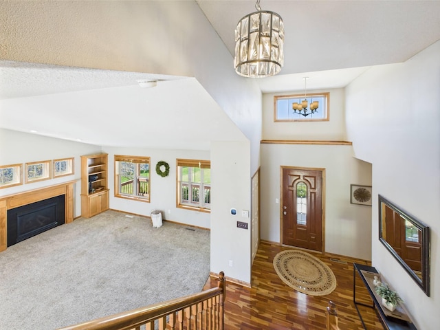 2200 Orchid Dr NE, Sauk Rapids, MN 56379 - entryway with wood finished floors, high vaulted ceiling, a fireplace, baseboards, and a chandelier