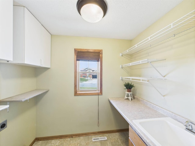 2200 Orchid Dr NE, Sauk Rapids, MN 56379 - washroom with baseboards, visible vents, a sink, hookup for an electric dryer, and cabinet space