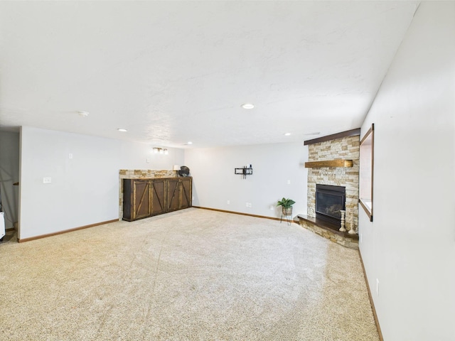 2200 Orchid Dr NE, Sauk Rapids, MN 56379 - unfurnished living room featuring bar area, baseboards, a stone fireplace, and carpet floors