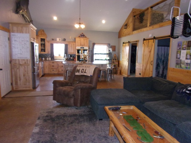 living area featuring recessed lighting, a barn door, and lofted ceiling