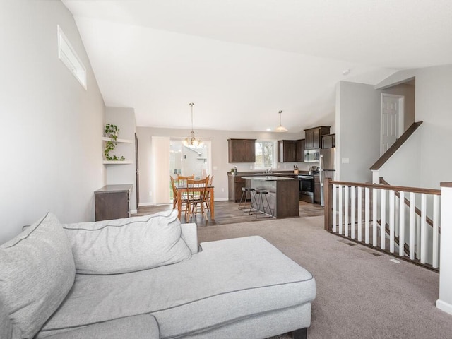living area featuring baseboards, light carpet, and vaulted ceiling