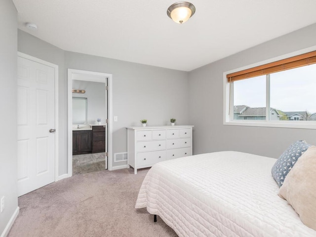 bedroom featuring light colored carpet, connected bathroom, baseboards, and visible vents