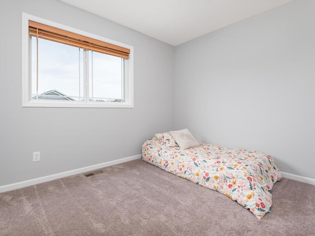 carpeted bedroom with visible vents and baseboards