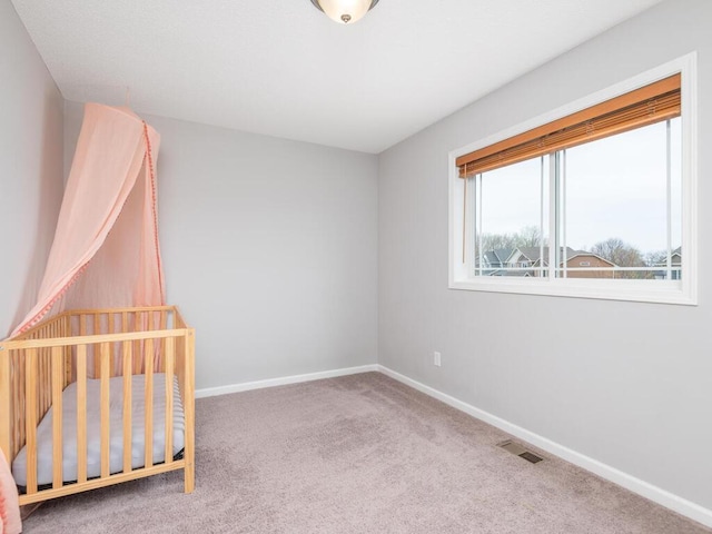 unfurnished bedroom featuring baseboards, visible vents, and carpet