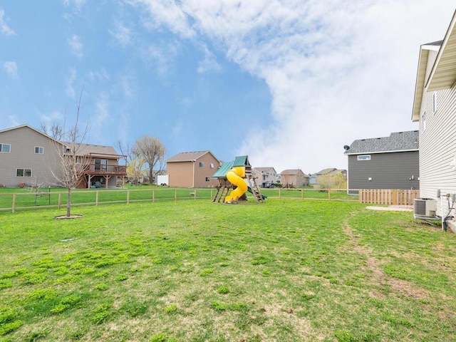 view of yard featuring a fenced backyard, central air condition unit, a residential view, and a playground
