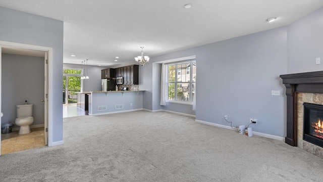 9645 Scott Ln N Unit 32, Brooklyn Park, MN 55443 - unfurnished living room featuring light colored carpet, a chandelier, a tiled fireplace, baseboards, and recessed lighting