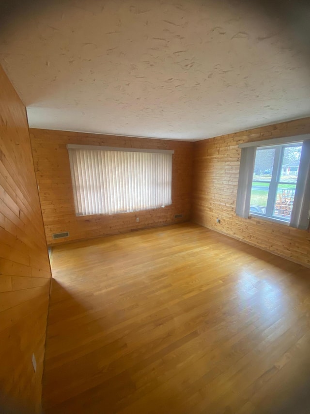 39 Erie St, Aurora, MN 55705 - unfurnished room with visible vents, light wood-style floors, and wooden walls