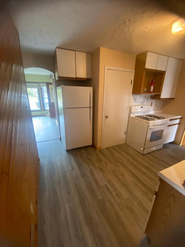 39 Erie St, Aurora, MN 55705 - kitchen featuring wood finished floors, white appliances, light countertops, white cabinets, and arched walkways
