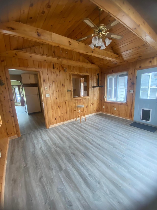 39 Erie St, Aurora, MN 55705 - unfurnished living room featuring wood ceiling, lofted ceiling with beams, wood walls, and wood finished floors
