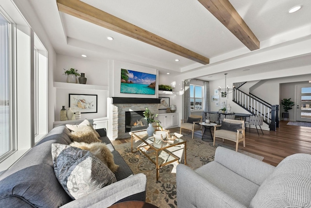 4181 Arbor Dr, Woodbury, MN 55129 - living area featuring a stone fireplace, stairs, wood finished floors, and a chandelier