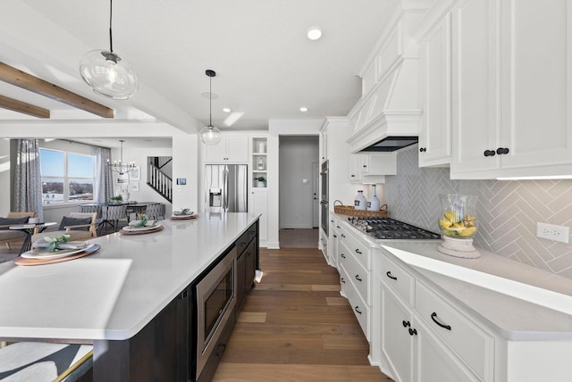 4181 Arbor Dr, Woodbury, MN 55129 - kitchen with wood finished floors, a spacious island, white cabinets, appliances with stainless steel finishes, and backsplash