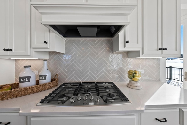 4181 Arbor Dr, Woodbury, MN 55129 - kitchen with stainless steel gas cooktop, white cabinets, wall chimney exhaust hood, and tasteful backsplash