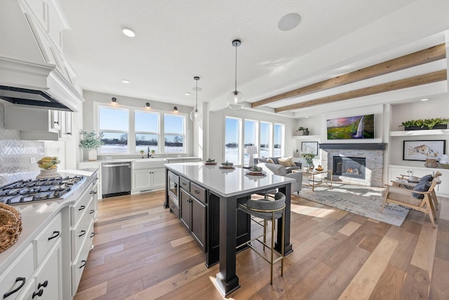 4181 Arbor Dr, Woodbury, MN 55129 - kitchen with white cabinets, light countertops, a center island, stainless steel appliances, and a kitchen bar