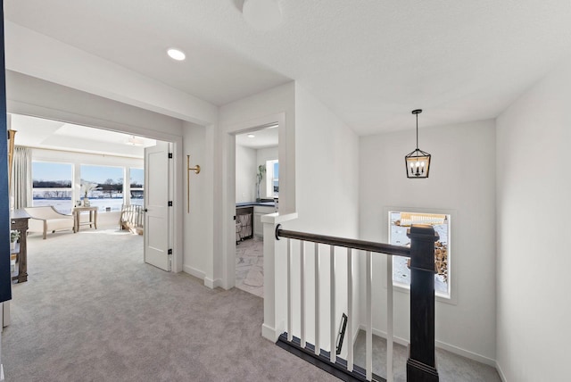 4181 Arbor Dr, Woodbury, MN 55129 - hall featuring a water view, plenty of natural light, a notable chandelier, and an upstairs landing