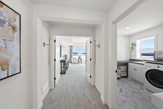 4181 Arbor Dr, Woodbury, MN 55129 - hallway with a sink, marble finish floor, washer / dryer, visible vents, and baseboards