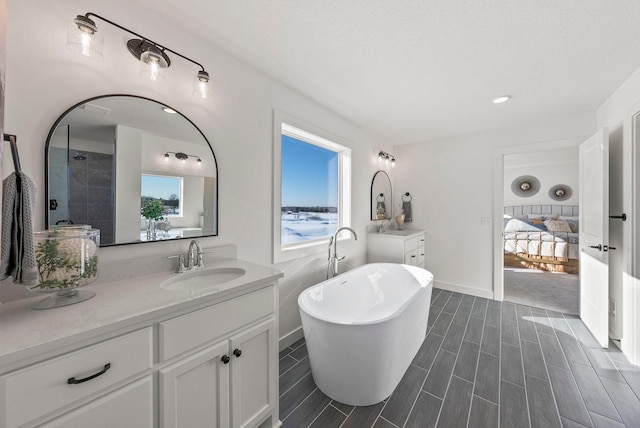 4181 Arbor Dr, Woodbury, MN 55129 - full bathroom with recessed lighting, baseboards, vanity, a freestanding bath, and wood finished floors