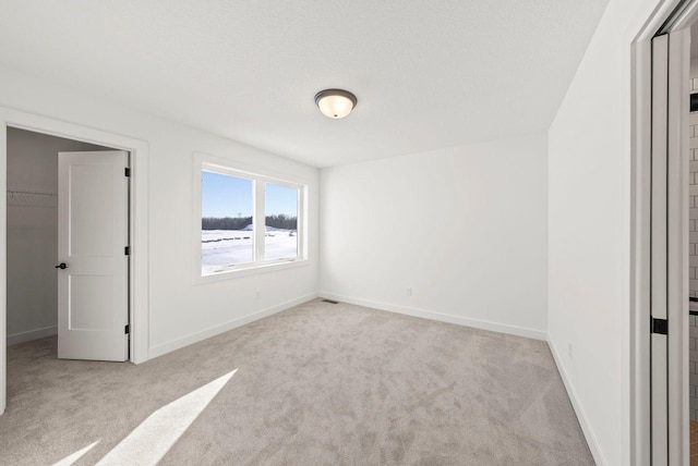 4181 Arbor Dr, Woodbury, MN 55129 - unfurnished bedroom with a closet, baseboards, a walk in closet, and carpet floors