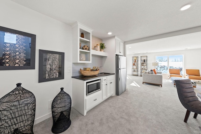 4181 Arbor Dr, Woodbury, MN 55129 - kitchen with dark countertops, recessed lighting, open shelves, light carpet, and stainless steel appliances