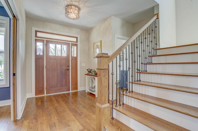 entrance foyer featuring plenty of natural light, wood finished floors, baseboards, and stairs