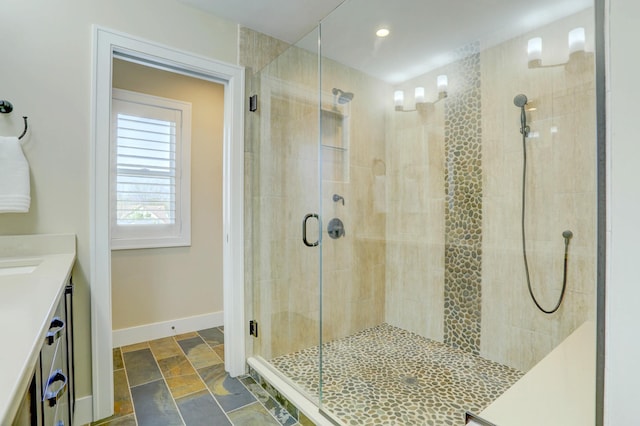 bathroom with vanity, recessed lighting, a shower stall, stone finish flooring, and baseboards